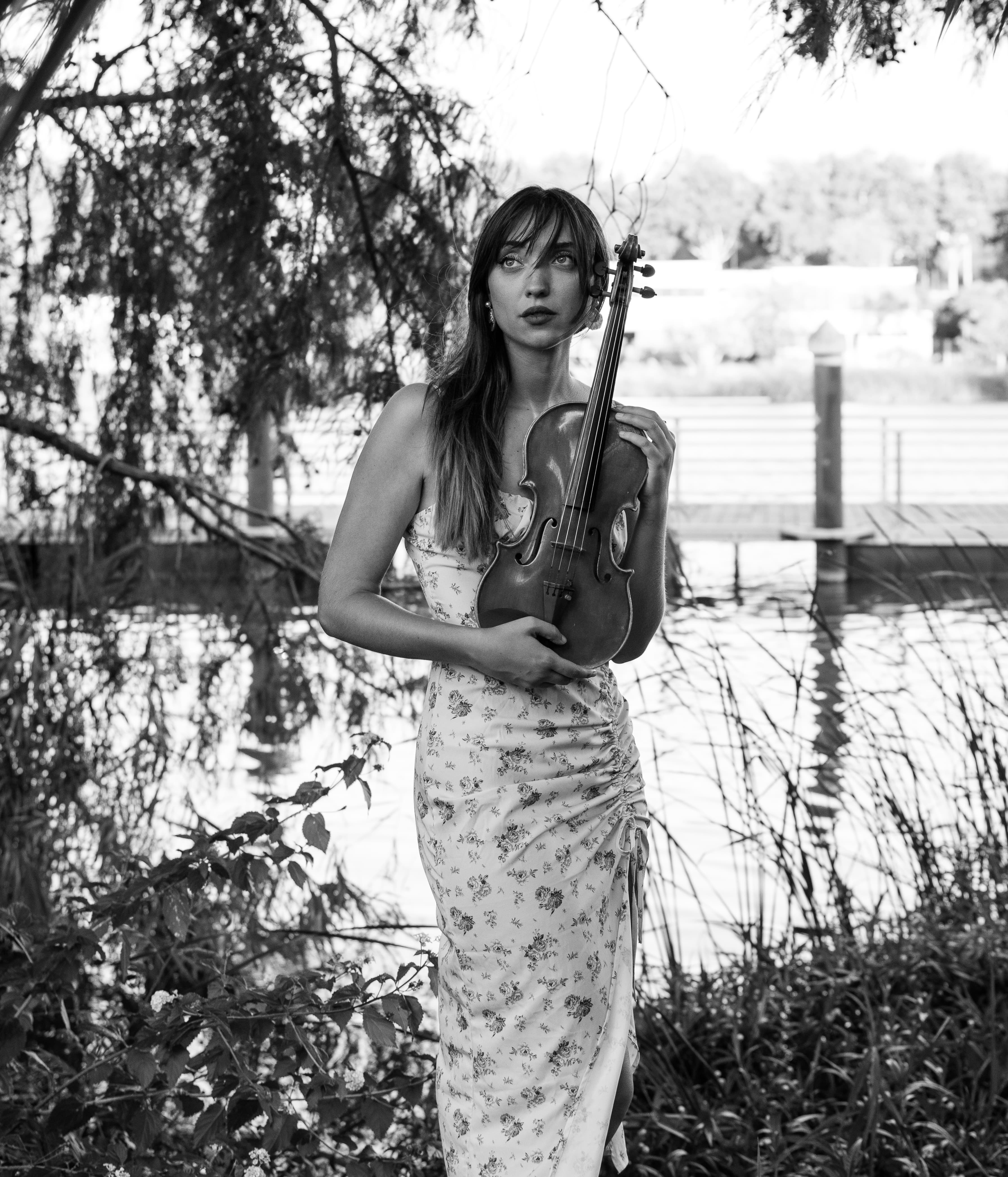 Raquel Reina Violinista con el violín en exteriores, junto al agua
